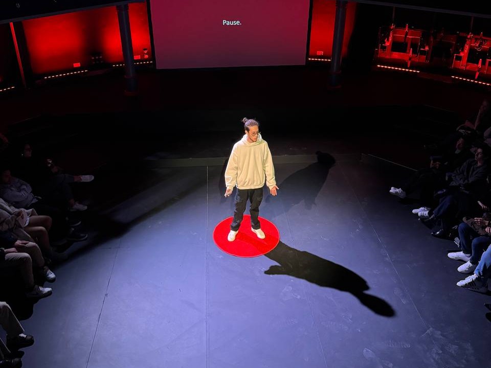 Marc Paul standing at a distance on the TEDxValletta stage